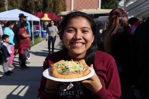 A student enjoying one of the selections of American Indian food available, fry bread, during the 2019 CSULB Pow Wow.