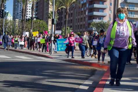 Demonstrators march down Ocean Boulevard as they advocate for access to feminine health care.