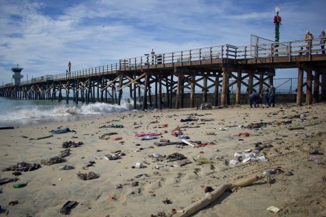Garbage and plastic are scattered along Seal Beach after high tides on Saturday morning.