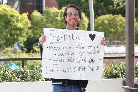 02/16/23 - CSULB student Joshua Brennecke holding his sign up near the escalators to encourage students as they walk by.