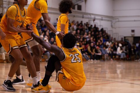 02/25/2023 - Long Beach, Calif: LBSU men's basketball player, Aboubacar Traore (#25) is helped up by his teammates during the Beach's matchup against CSUN inside the Gold Mine.