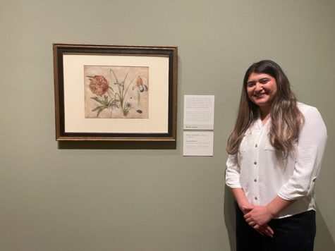 Brianna Aguilera standing next to her written interpretation of "flowers and beetles" by Hans Hoffman.