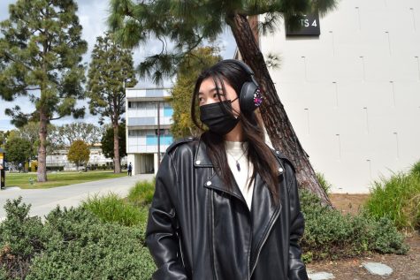 First-year fine art major Kae Ma layers a black leather jacket over a white t-shirt. Ma accessorizes with an amethyst crystal necklace and a pair of decorated headphones.
