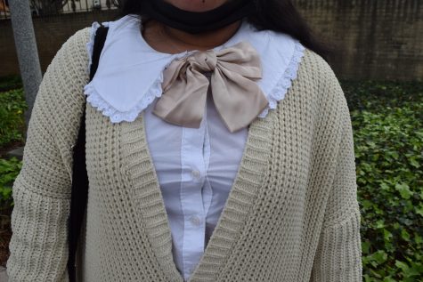 First-year liberal studies major Jay Cui Aguirre layers a white frilled-collar blouse, a satin bow and a beige cardigan.