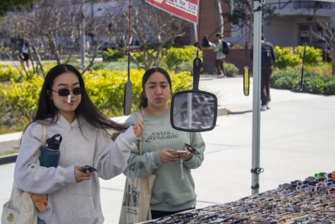 (left to right) Second year pre-nursing majors Angie Nguyen and Bella Villegas checking out some sunglasses at the campus flea market outside the bookstore.