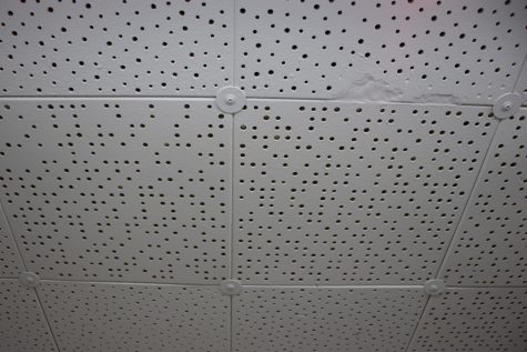 Facilities maintenance added screws and washers to the ceiling tiles to prevent them from falling out. The little holes in the tiles are also how the building gets ventilated, but in some rooms the holes got painted over and the rooms didn't have proper air flow to do their job.