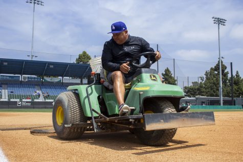 Rene Garcia drives a small tractor with a nail drag on the infield dirt before the Long Beach State Dirtbags game against the Cal State Northridge Matadors on April 16, 2023.