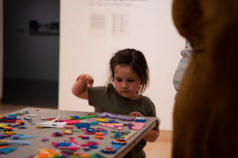 09/14/2023 - Long Beach, Calif: Bowie Harvey creates her own art piece at the interactive table. She is four years old and was visiting the exhibit with her mother.
