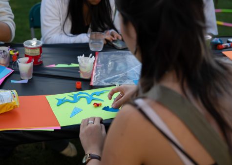 The event hosted activities outside the exhibit, like this arts and crafts table. Annette Choi cuts out a dragon using construction paper and scissors provided to participants.