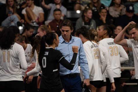08/25/2023 - Long Beach, Calif: Long Beach State women's volleyball head coach Tyler Hildebrand (middle, blue) talks defensive adjustments with junior defensive specialist Savana Chacon during the Beach's matchup against the University of Texas at Austin Longhorns. The Beach would upset the reigning national champion Longhorns 3-1 in the season-opener inside the Walter Pyramid.