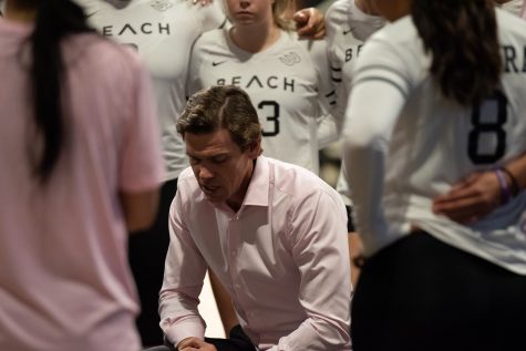 Long Beach State women's volleyball head coach Tyler Hildebrand talks strategy with his team during the third set of the Beach's matchup against UC Davis inside the Walter Pyramid on Oct. 13, 2023.
