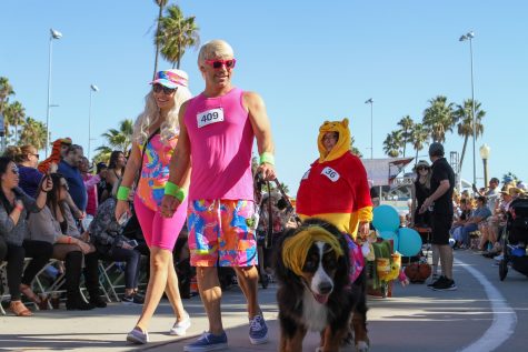 10/29/23 BELMONT SHORE, CALIF: Barbie and Ken walk their dog along the parade route.