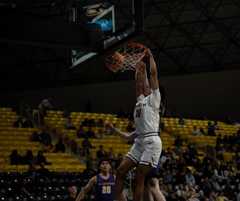 Sophomore guard AJ George gets up for a dunk as LBSU dominates scoring half of their points in the paint. George finished the game with nine points and six rebounds.