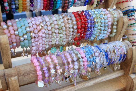 11/5/2023 - Long Beach, Calif: Luna Crystals, 16-year-old Emily Huerta's business, displays rows of colorful beaded charm bracelets at The Beach Flea Market.