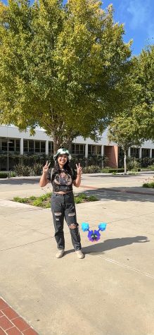Caroline, or asparguskillr on Pokémon Go, posing next to her buddy Pokémon, Cosmog.