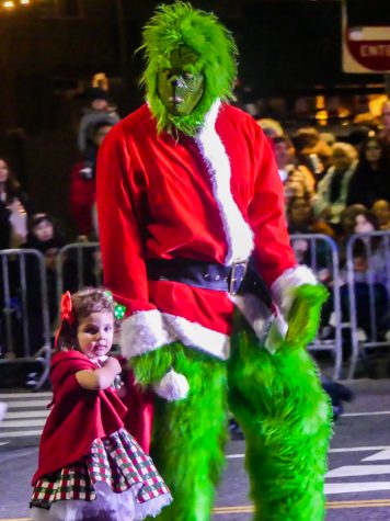 The grinch and little Sally were spotted roaming the parade, frowning upon the festivities, while spectators waved. The grinch stopped to take photos with families and kids.