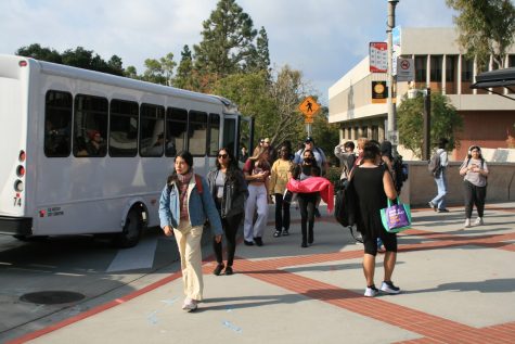 12/08/2023  -  Long Beach, Calif: CSULB students exit the west loop shuttle at Brotman Hall as they head to class. Photo credit: Carlos Yakimowich.