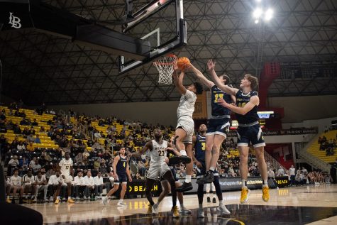 Long Beach State men's basketball sophomore guard AJ George goes up for a layup over two UC San Diego defenders in their matchup inside the Walter Pyramid. George would finish the game with 11 points on 4-7 shooting as the Beach would beat the Tritons 85-76.