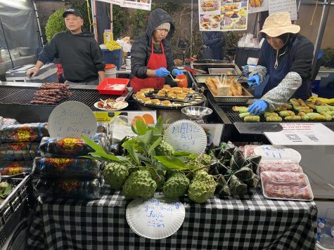 At this vendor's stall, three cooks prepare different Vietnamese specialties: BBQ pork skewers, .... filled with shredded coconut and .... In the front, there are seasonal Tết items, like soursop and Bánh Tét, a savory rice cake wrapped in banana leaf.