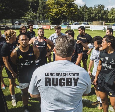 Long Beach State Club Rugby Director Jason Reynolds stands in front of his team that has been persevering through financial struggles. As director of the program, Reynolds is actively working to secure more funding and support for his team.