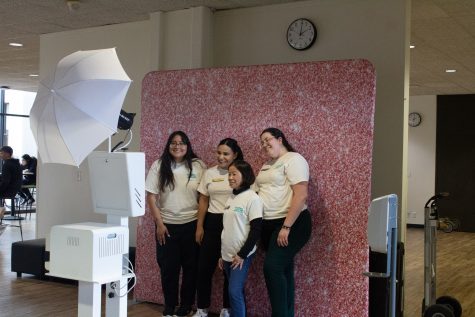 Members of the Women's Gender and Equity Center pose at the photo booth that was available for attendees to use at the entrance of the Women's History Month Kickoff.