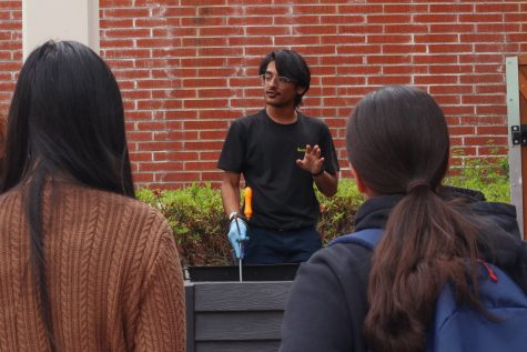 Parth Balchandani, an ASI sustainability assistant, gives a tour of the Grow Beach Garden to the event's participants.